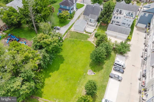 an aerial view of residential houses with outdoor space and trees all around