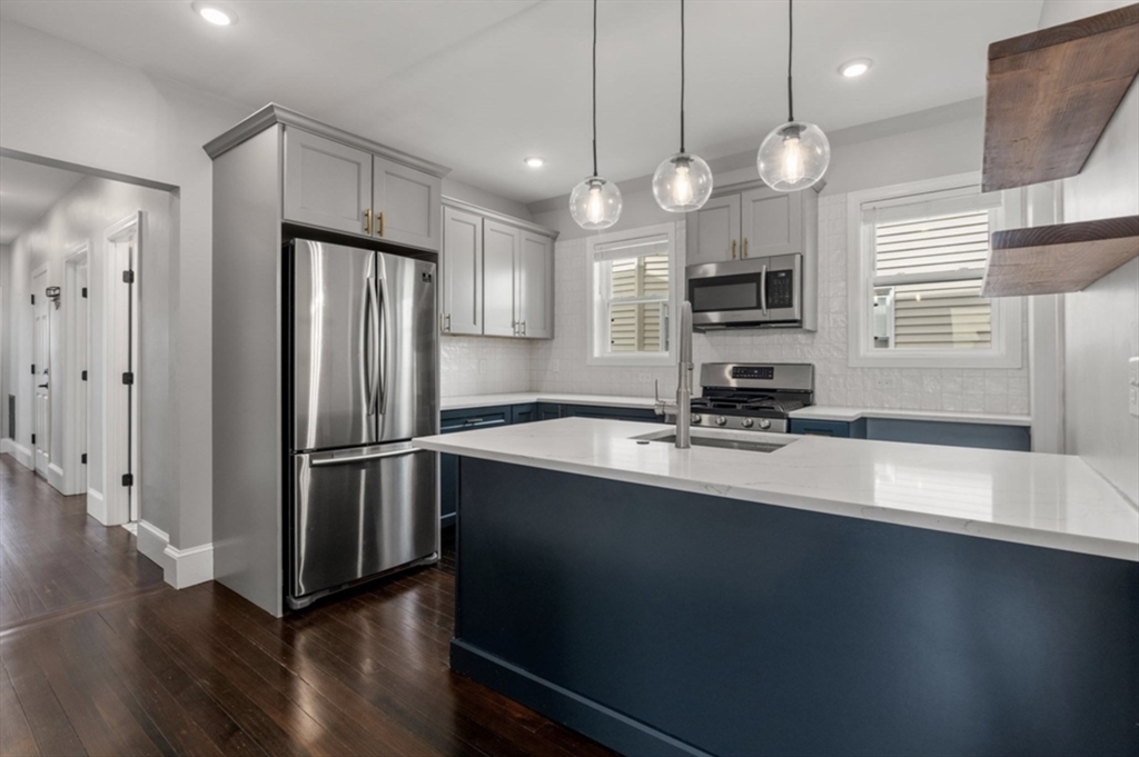 a kitchen with stainless steel appliances a refrigerator sink and microwave