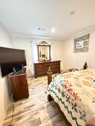 a bedroom with bed and flat screen tv