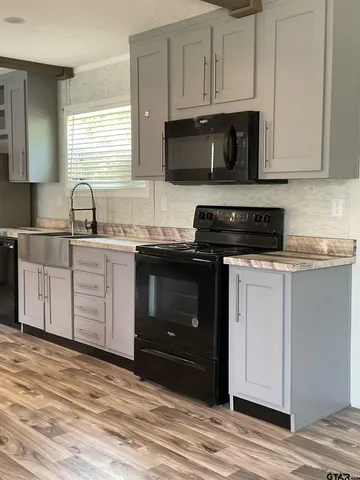 a kitchen with white cabinets and sink