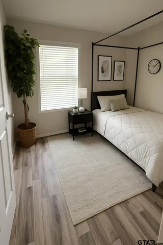 a bedroom with a bed a couch and a potted plant