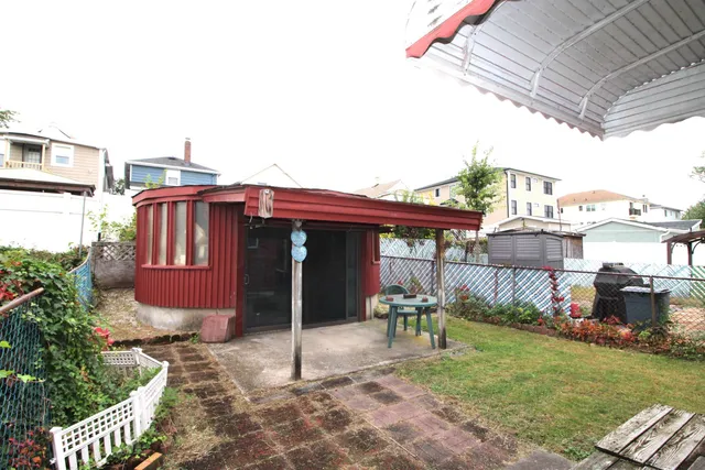 a backyard of a house with table and chairs