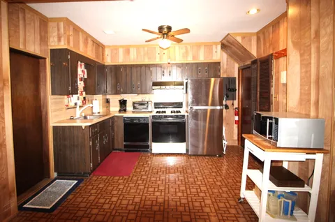 a kitchen with stainless steel appliances granite countertop a refrigerator a stove and a sink
