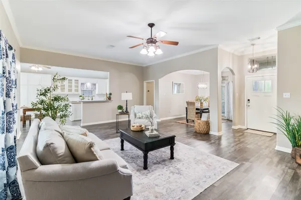 a kitchen with stainless steel appliances kitchen island granite countertop a stove a sink a refrigerator and white cabinets with wooden floor