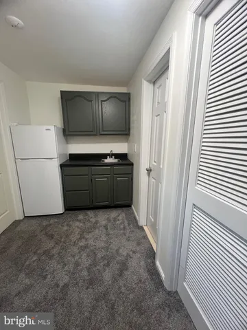 a view of kitchen with furniture and refrigerator