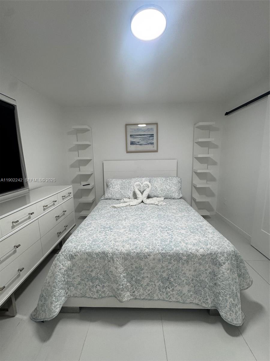 7965 Northwest 8th Street, Unit 23E Miami, FL 33126 - Photo 9 of 11 a bedroom with a bed and dresser