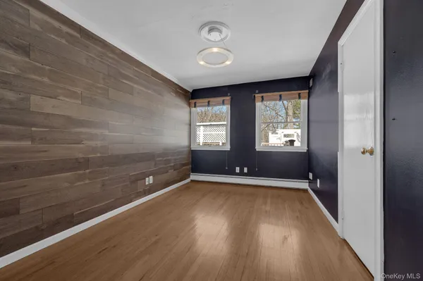 a view of an empty room with a window and wooden floor