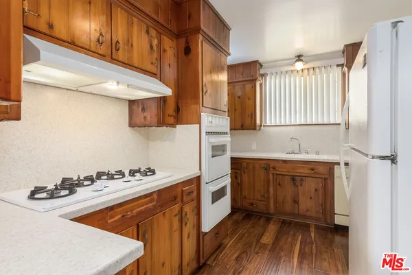 a kitchen with granite countertop a sink cabinets stainless steel appliances and a counter
