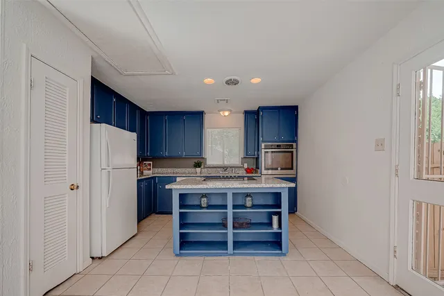 a view of kitchen with refrigerator microwave and cabinets