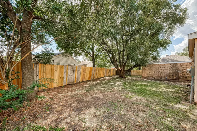 a view of a house with a large tree and a yard