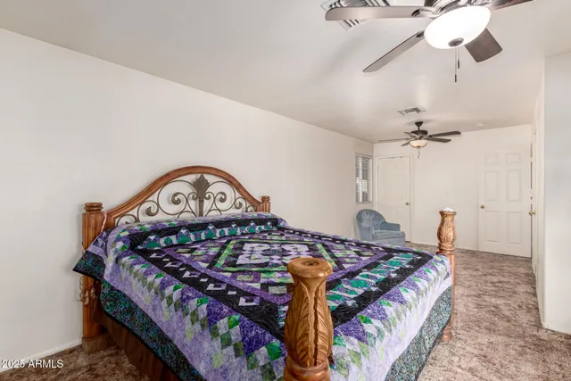 a bedroom with a bed next to a window with a chandelier