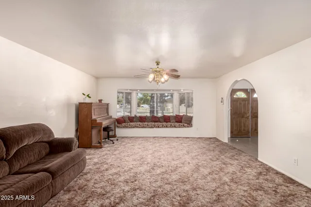 a living room with furniture a chandelier and a rug