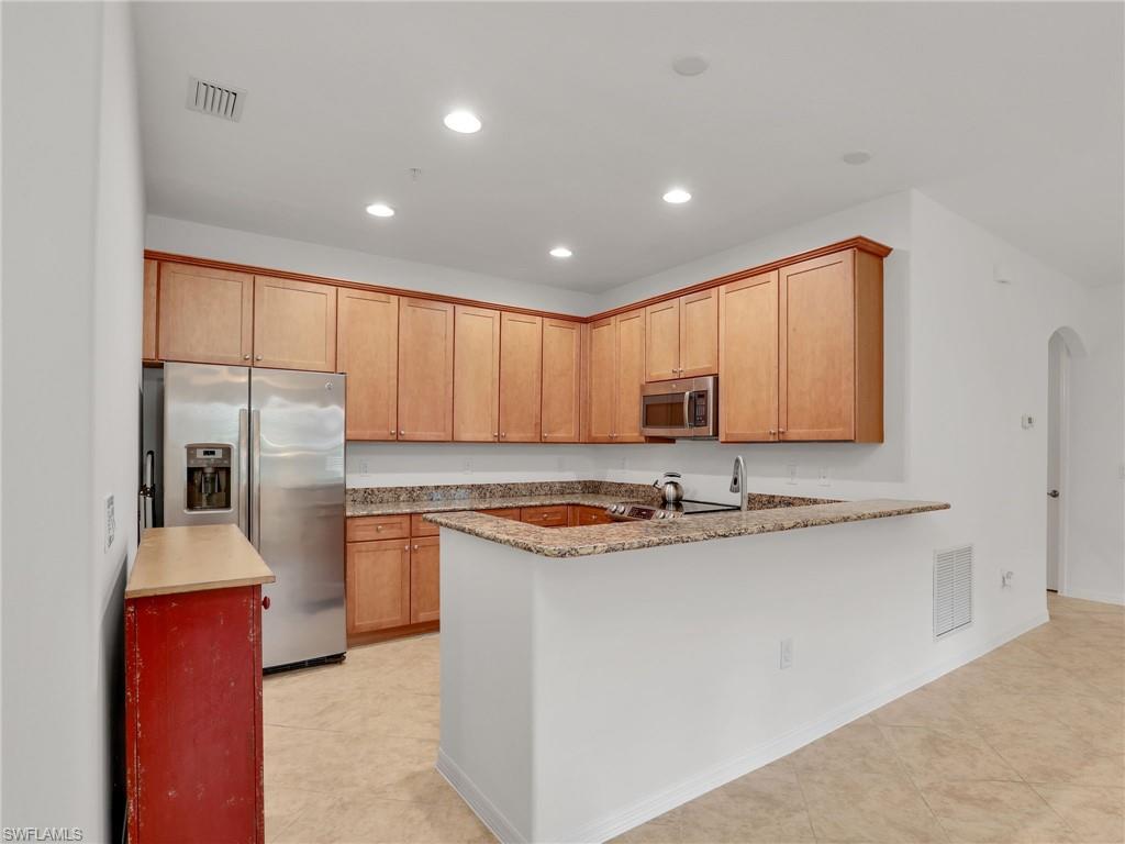 9066 Albion Lane North, Unit 5103 Naples, FL 34113 - Photo 11 of 40 a kitchen with stainless steel appliances granite countertop a sink and a stove
