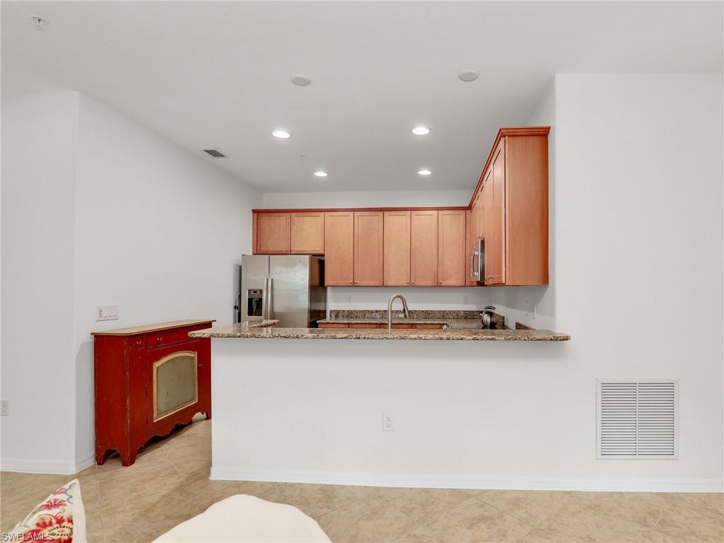 9066 Albion Lane North, Unit 5103 Naples, FL 34113 - Photo 12 of 40 a kitchen with stainless steel appliances granite countertop a sink a stove and a refrigerator