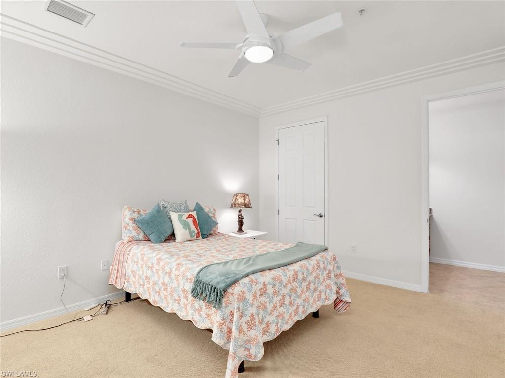 9066 Albion Lane North, Unit 5103 Naples, FL 34113 - Photo 17 of 40 a bedroom with a bed and a night stand