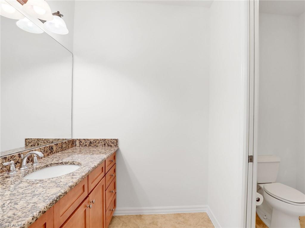9066 Albion Lane North, Unit 5103 Naples, FL 34113 - Photo 19 of 40 a bathroom with a granite countertop sink and a mirror