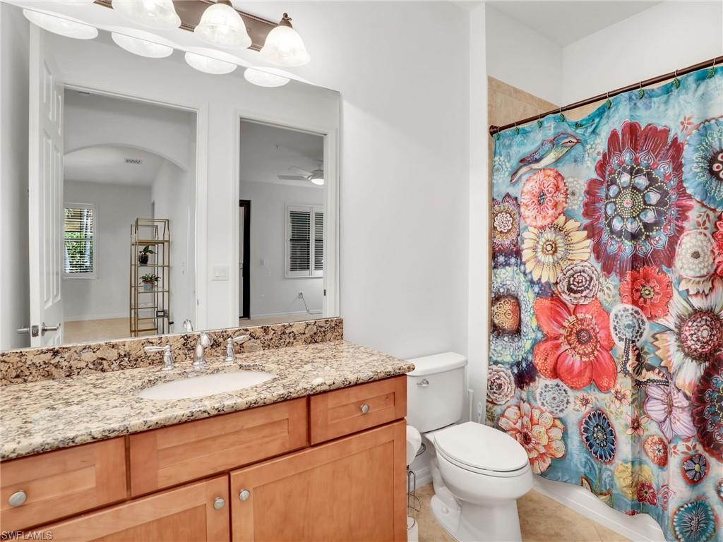9066 Albion Lane North, Unit 5103 Naples, FL 34113 - Photo 24 of 40 a bathroom with a granite countertop sink a toilet and a mirror