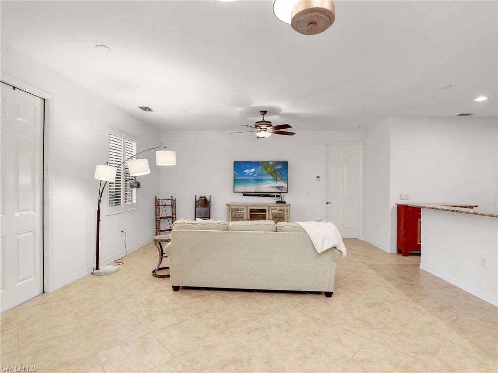 9066 Albion Lane North, Unit 5103 Naples, FL 34113 - Photo 5 of 40 a living room with a bed furniture and a flat screen tv