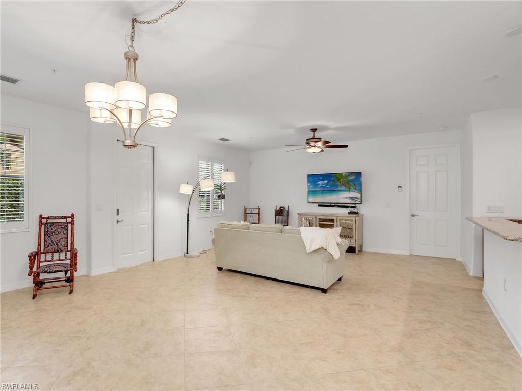 9066 Albion Lane North, Unit 5103 Naples, FL 34113 - Photo 7 of 40 a living room with furniture and a chandelier