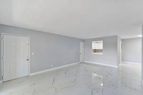 an empty room with sliding door and windows