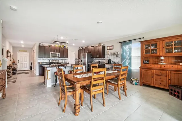 a dining area with stainless steel appliances kitchen island granite countertop a table and chairs