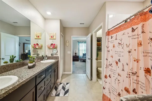 a bathroom with a granite countertop sink a mirror and shower