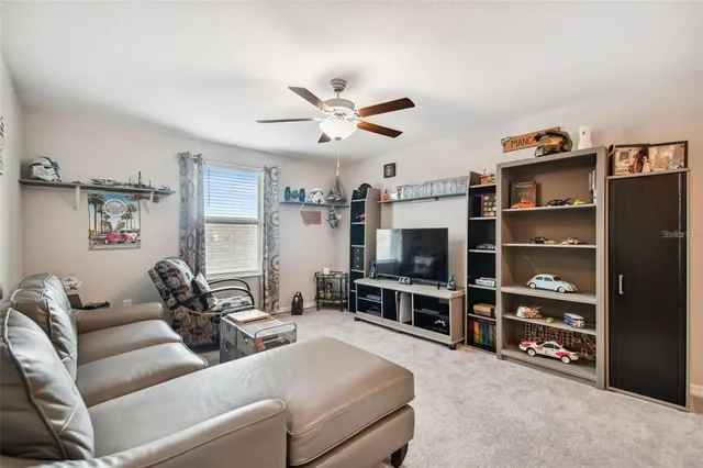 a living room with furniture a flat screen tv and gym equipment