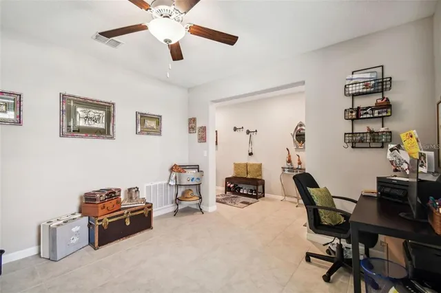 a view of a workspace with furniture and a ceiling fan