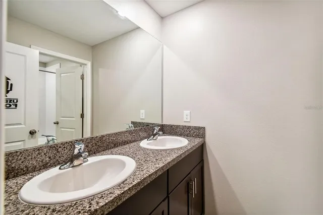 a bathroom with a granite countertop sink and a mirror