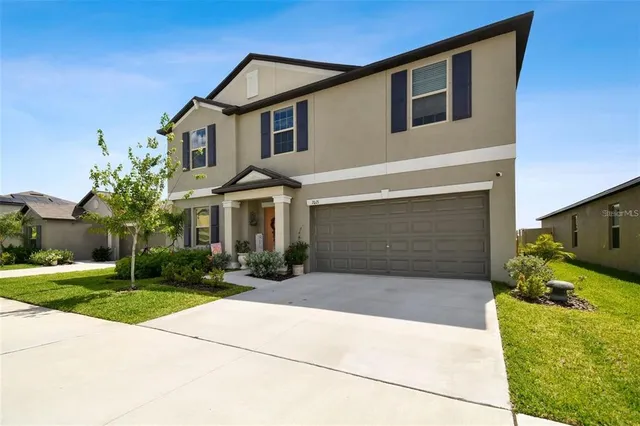 a front view of a house with yard and parking