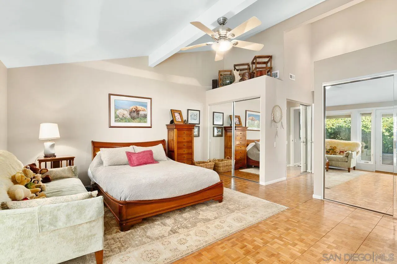 2224 Caminito Cabala La Jolla, CA 92037 - Photo 17 of 36 a bedroom with a large bed and a chandelier