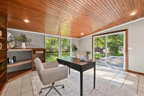 a dining room with furniture and a garden view