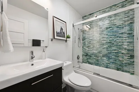 a bathroom with a sink a toilet and shower