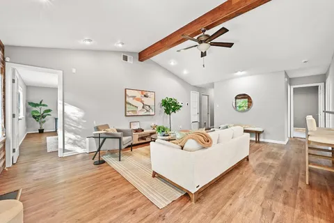 a living room with furniture and a wooden floor