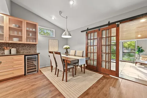 a dining room with furniture a chandelier and wooden floor