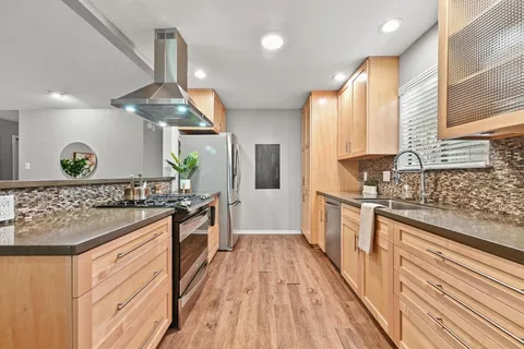 a kitchen with stainless steel appliances granite countertop a stove and a sink