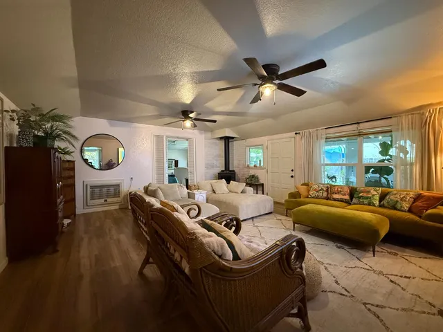 a living room with furniture a ceiling fan and a flat screen tv