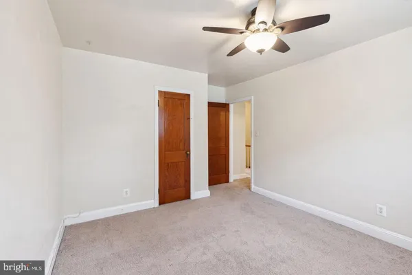 an empty room with closet and a chandelier fan
