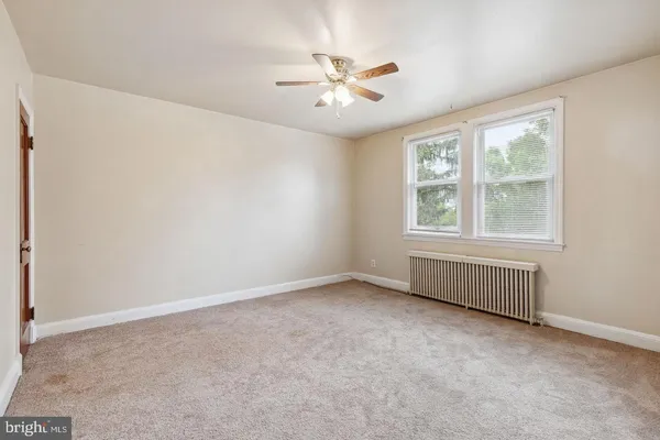 an empty room with a window and a ceiling fan