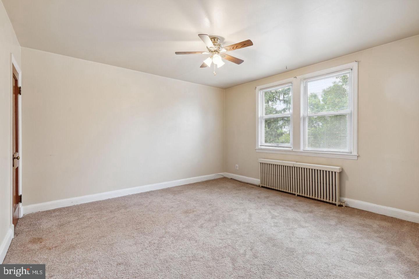 902 Elm Ridge Avenue Baltimore, MD 21229 - Photo 3 of 15 an empty room with a window and a ceiling fan