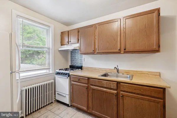 a kitchen with a sink cabinets appliances and a window