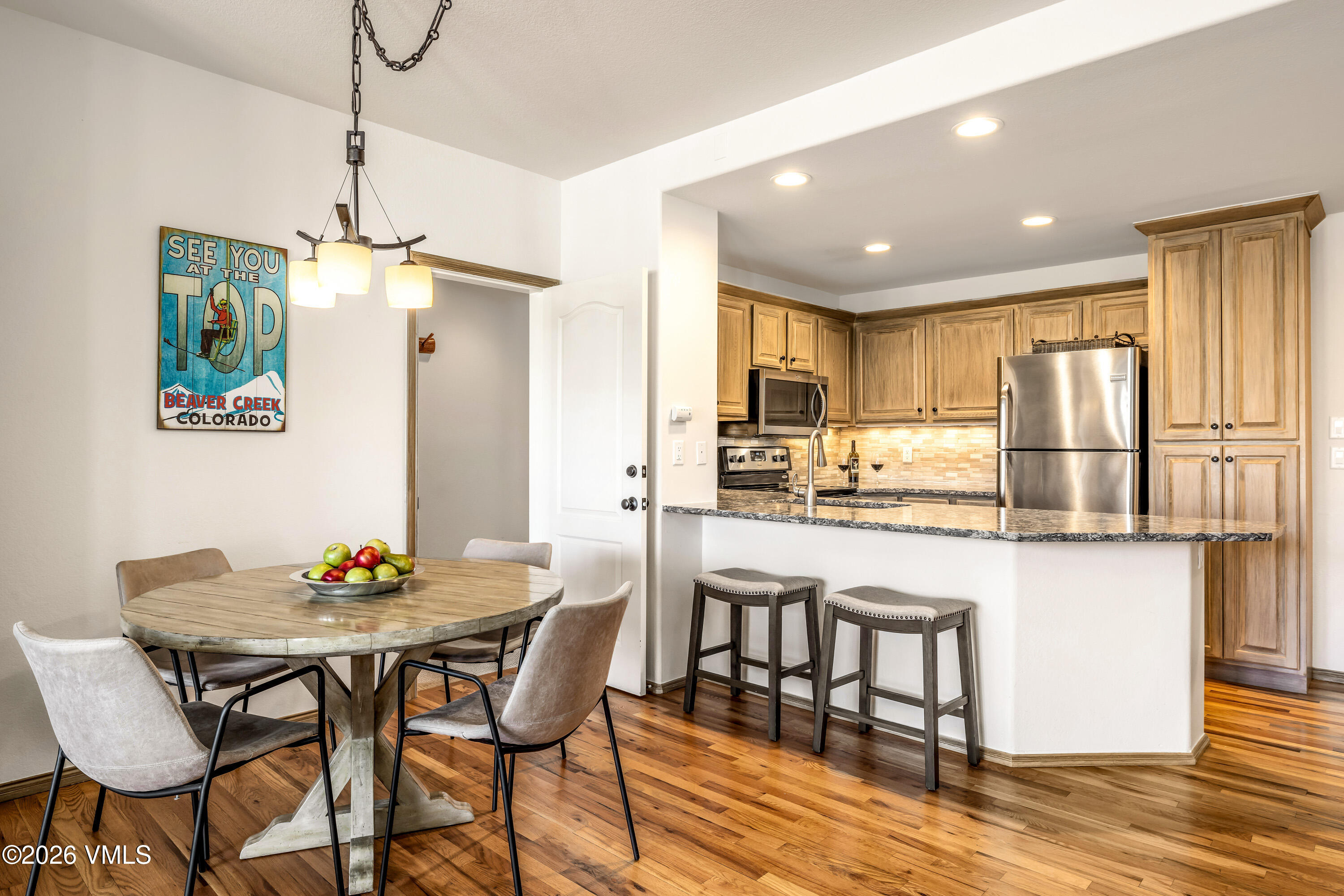 600 Sawatch Drive, Unit 101 Edwards, CO 81632 - Photo 5 of 34 a kitchen with stainless steel appliances granite countertop a dining table chairs refrigerator and microwave