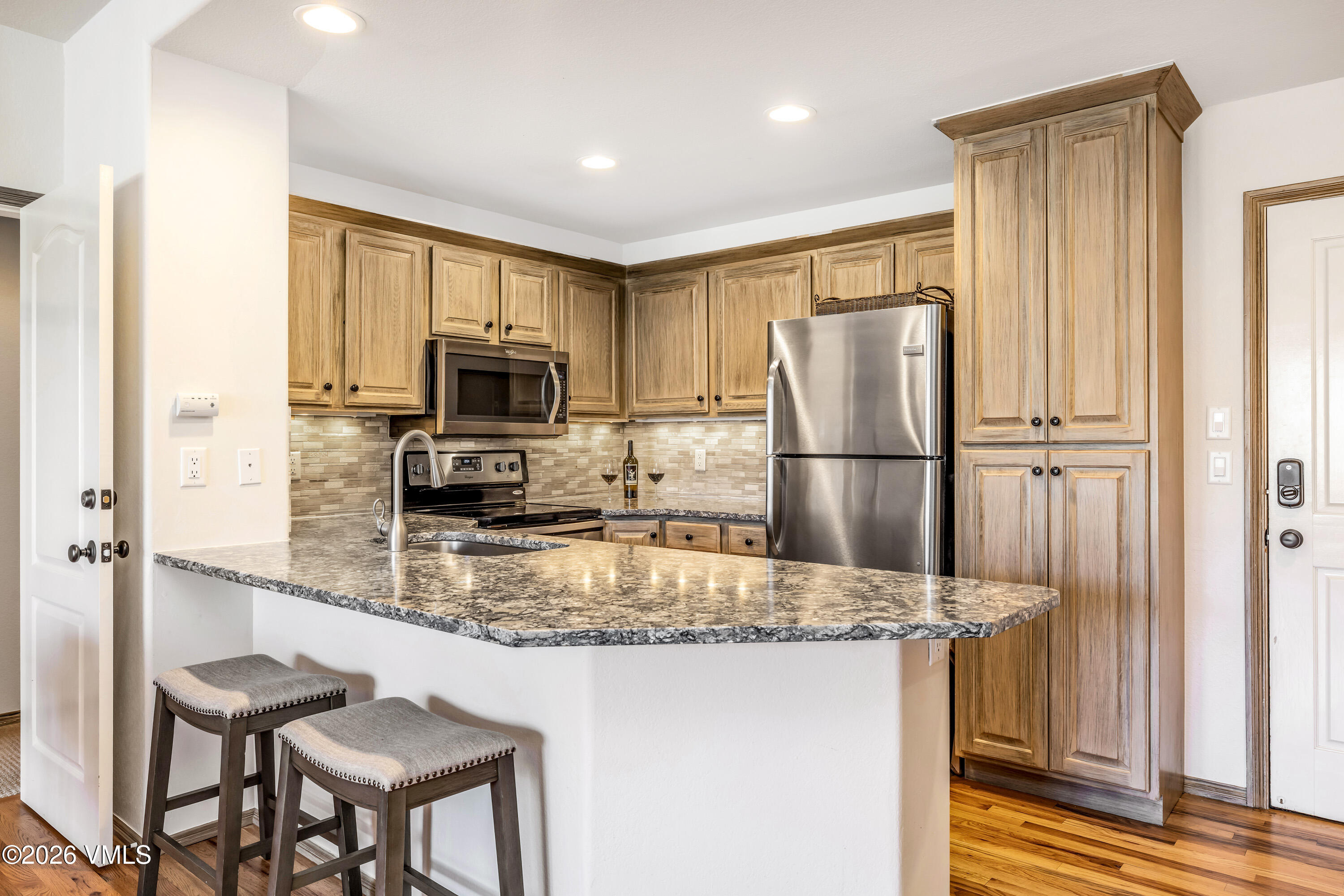600 Sawatch Drive, Unit 101 Edwards, CO 81632 - Photo 6 of 34 a kitchen with granite countertop a refrigerator and a stove top oven