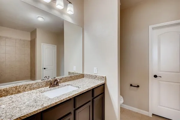 a bathroom with a granite countertop sink and a mirror