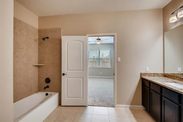a bathroom with a tub shower and sink