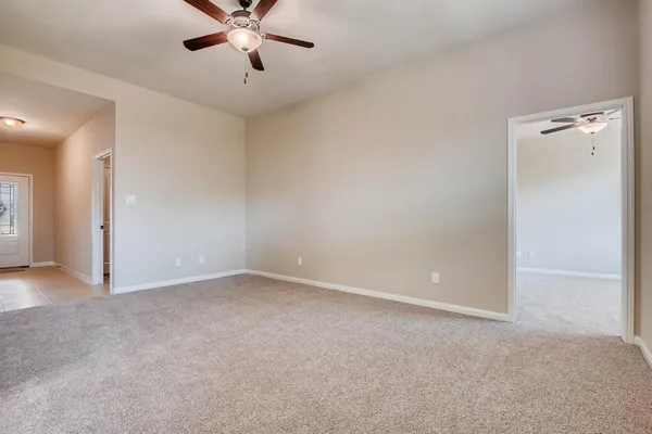 an empty room with closet and a chandelier fan