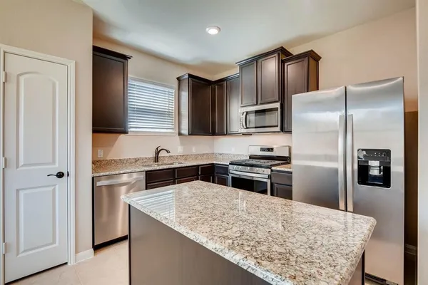 a kitchen with stainless steel appliances granite countertop a refrigerator stove and oven