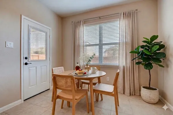a dining room with furniture and potted plants