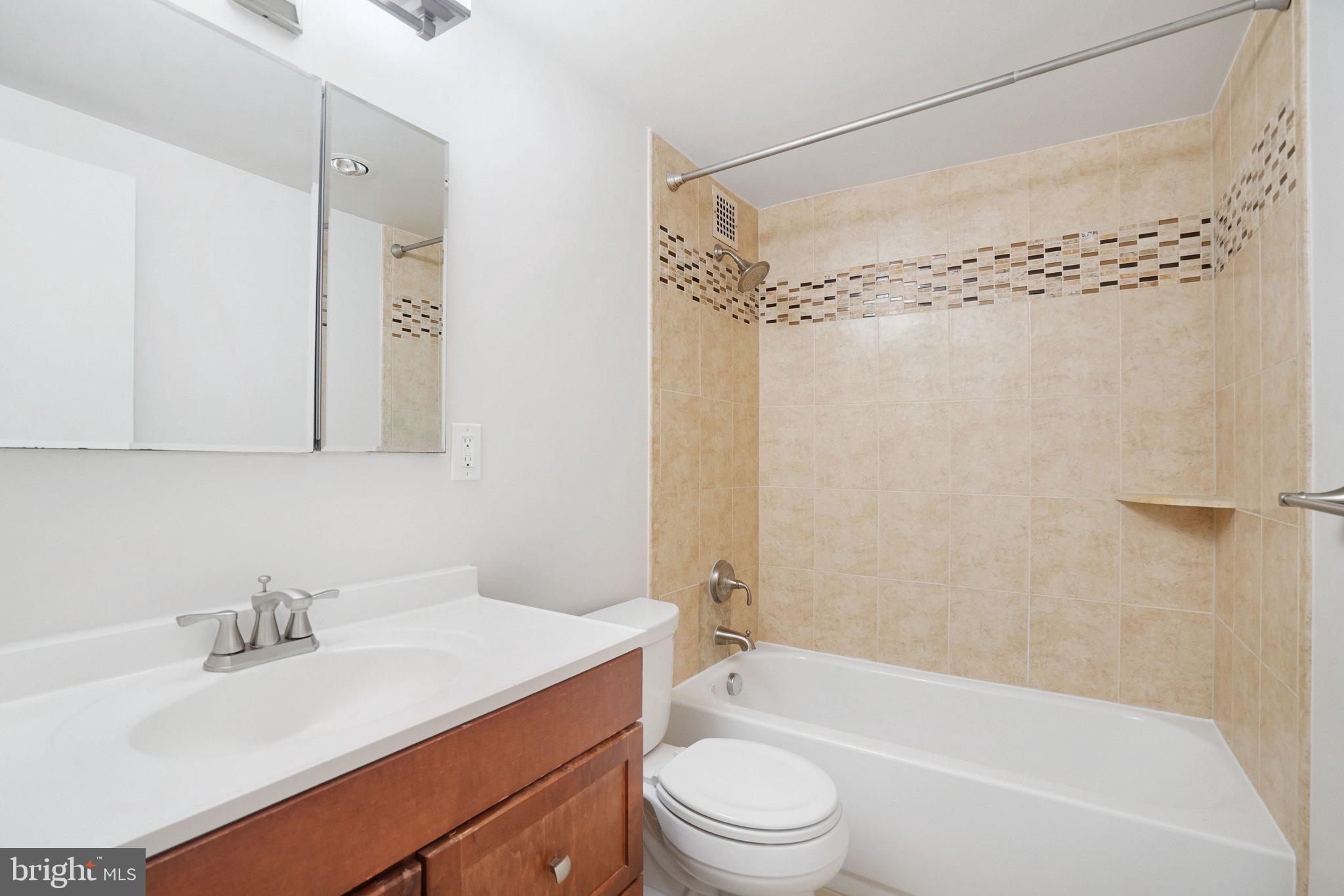 4141 North Henderson Road, Unit 303 Arlington, VA 22203 - Photo 9 of 37 a bathroom with a granite countertop sink mirror toilet and bathtub