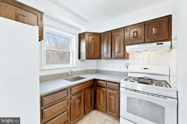 a kitchen with granite countertop a sink stove and cabinets
